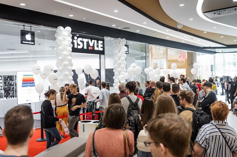 A large crowd of apple fans are seen outside a hi tech shop in a mall