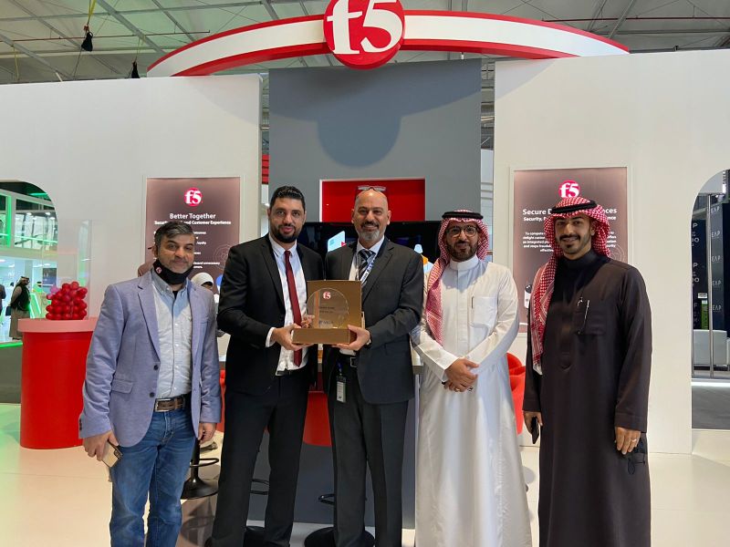 five men are seen at a technology exhibition passing a trophy to each other