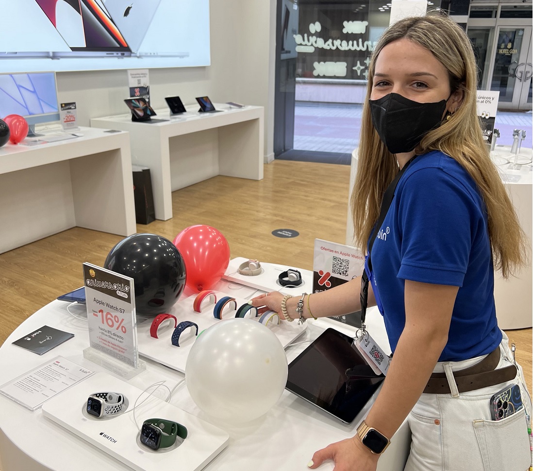 on the right of the image, a woman is seen looking at a display of Apple watches
