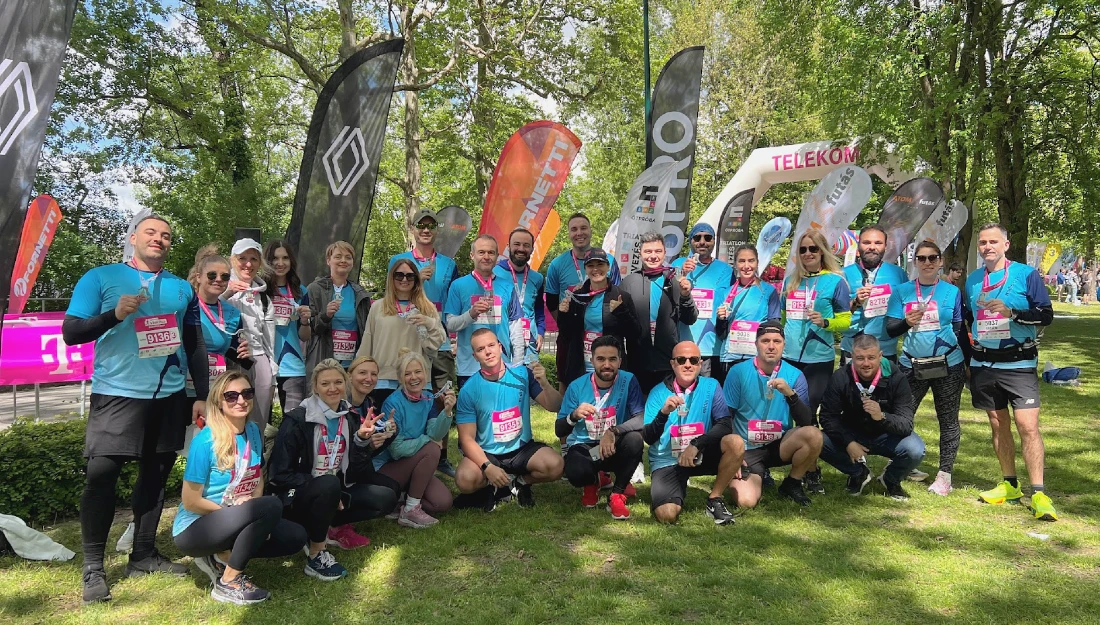 un groupe de coureurs en t-shirts bleus se reposent après une course de semi-marathon à l'ombre des arbres dans un parc