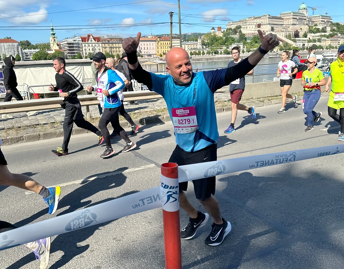 un homme vêtu d'un t-shirt bleu passe devant les spectateurs, les bras levés.