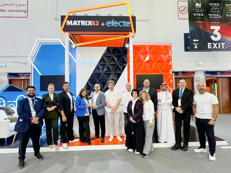 13 personnes sont vues sur un stand d'exposition tandis que deux personnes au centre acceptent un trophée 