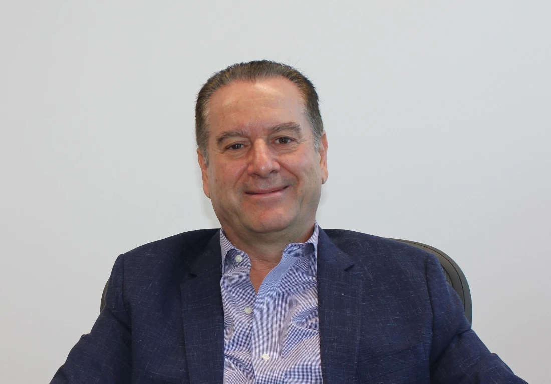 a man is seen sitting at a desk looking at the camera
