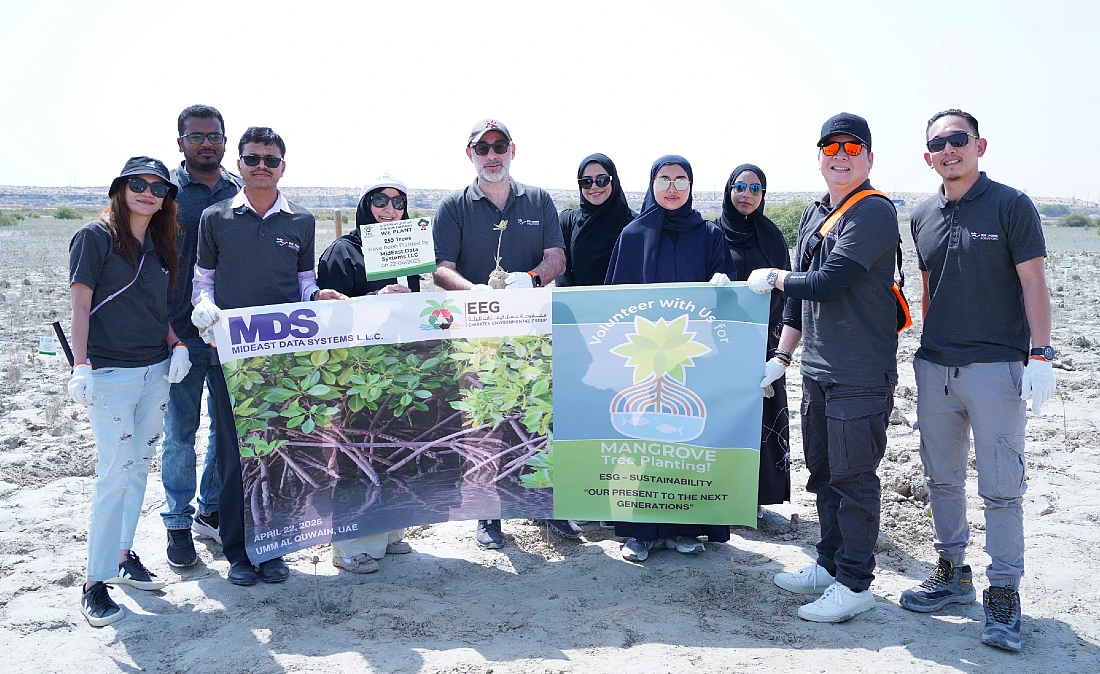 ten people are seen holding a banner outdoors on a beach