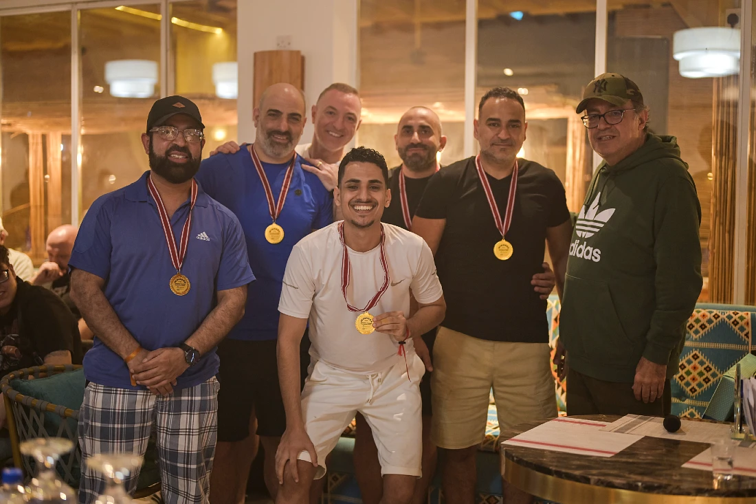 sept hommes sur une photo de groupe, dont quatre portant des médailles d’or.