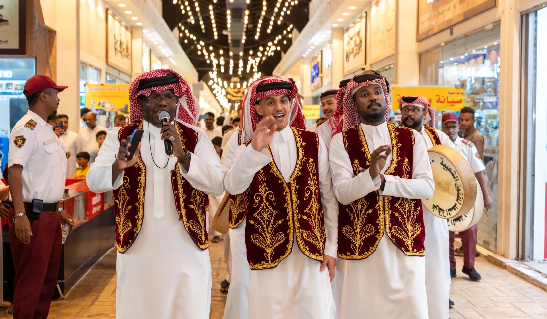 Three members of a traditional music group are seen singing in a shopping centre