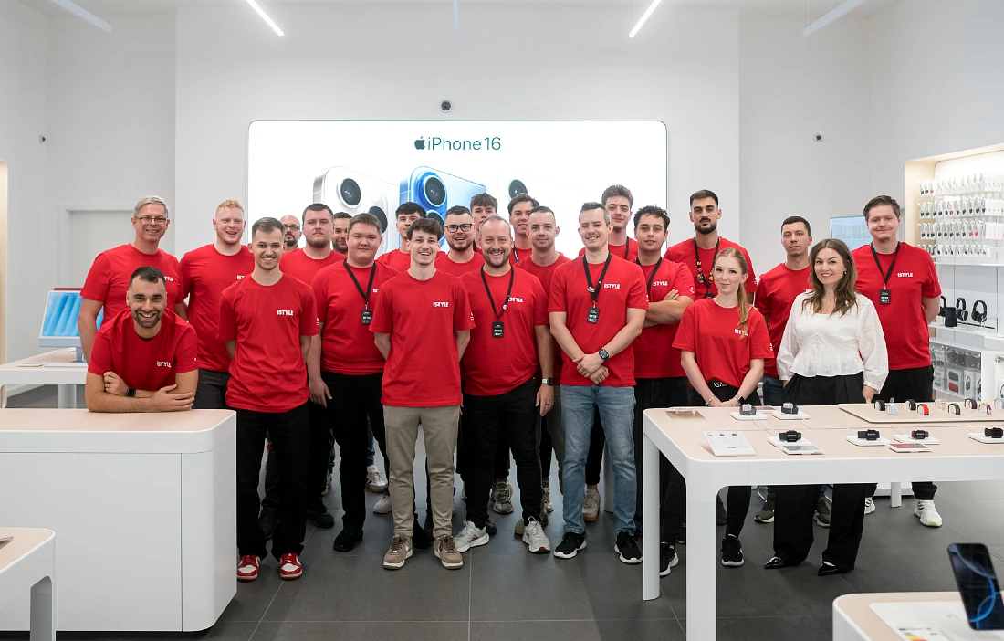 A team photo of the people who work in a hi-tech store. They are mostly wearing red t-shirts