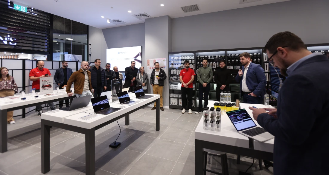 Un membre de l'équipe iSTYLE en magasin présente un produit depuis un ordinateur portable à un groupe de participants lors de l'événement B2B.