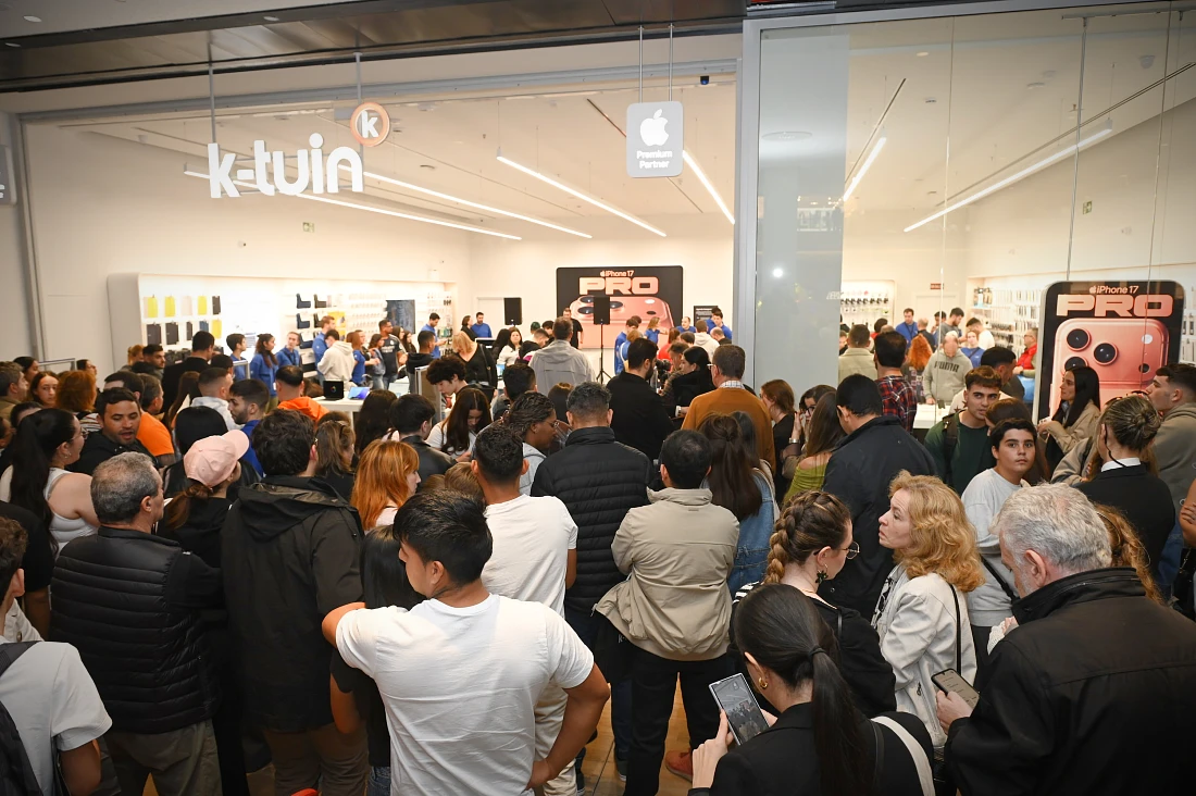 Une foule importante se rassemble devant un magasin high-tech.