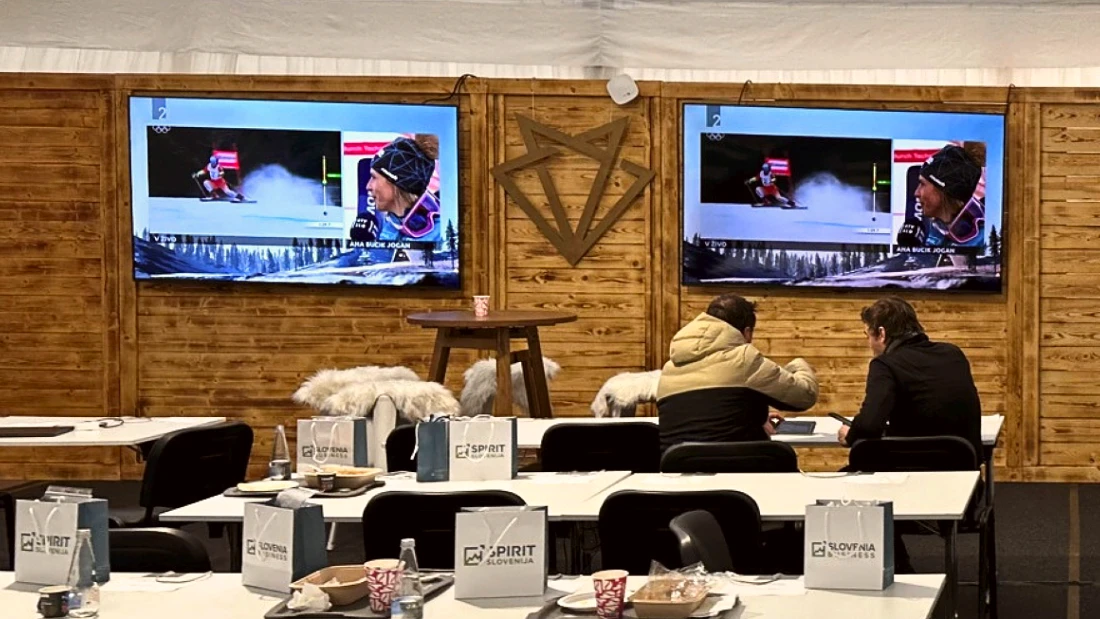 A media center is seen with desks, snacks for journalists and screens on the wall 