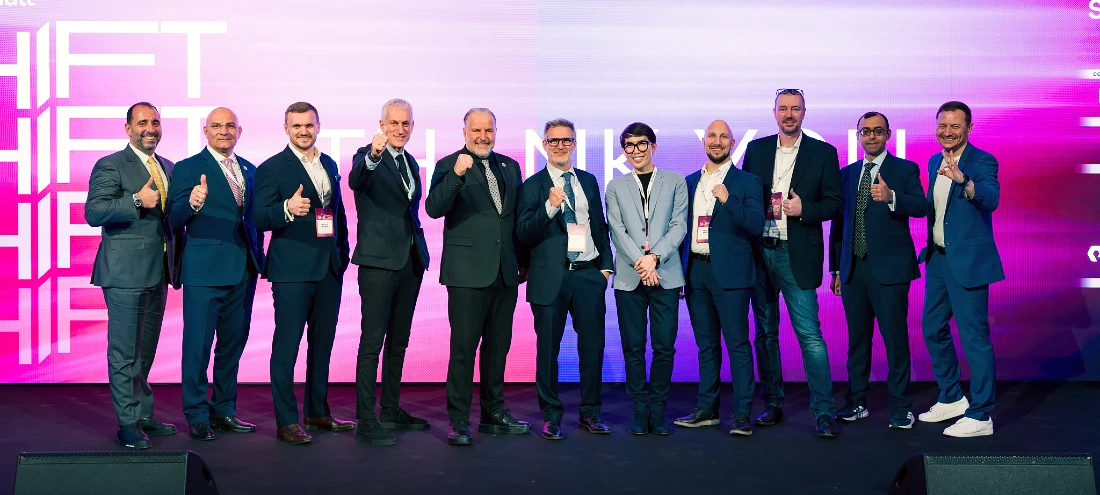 11 men in suits are seen in a group photograph.