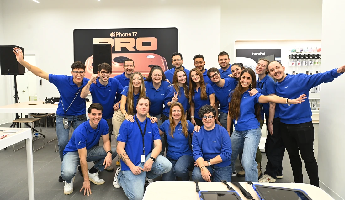 Photo de groupe de personnes souriantes en t-shirts bleus dans un magasin high-tech