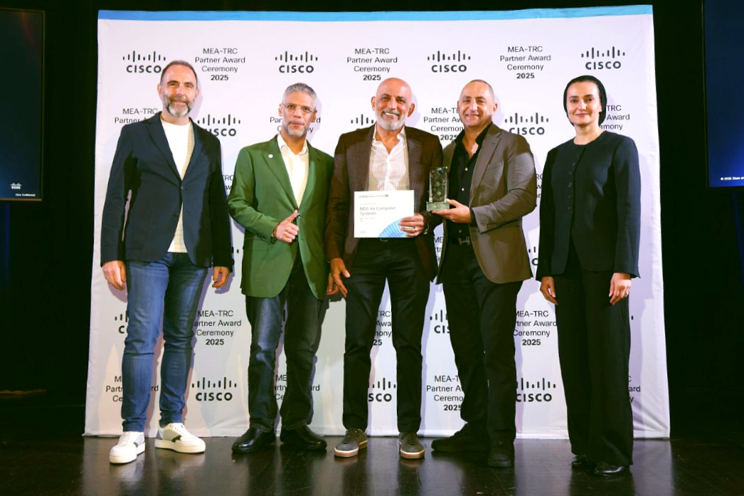 Five people on stage at an award ceremony, with the central figure holding an award certificate