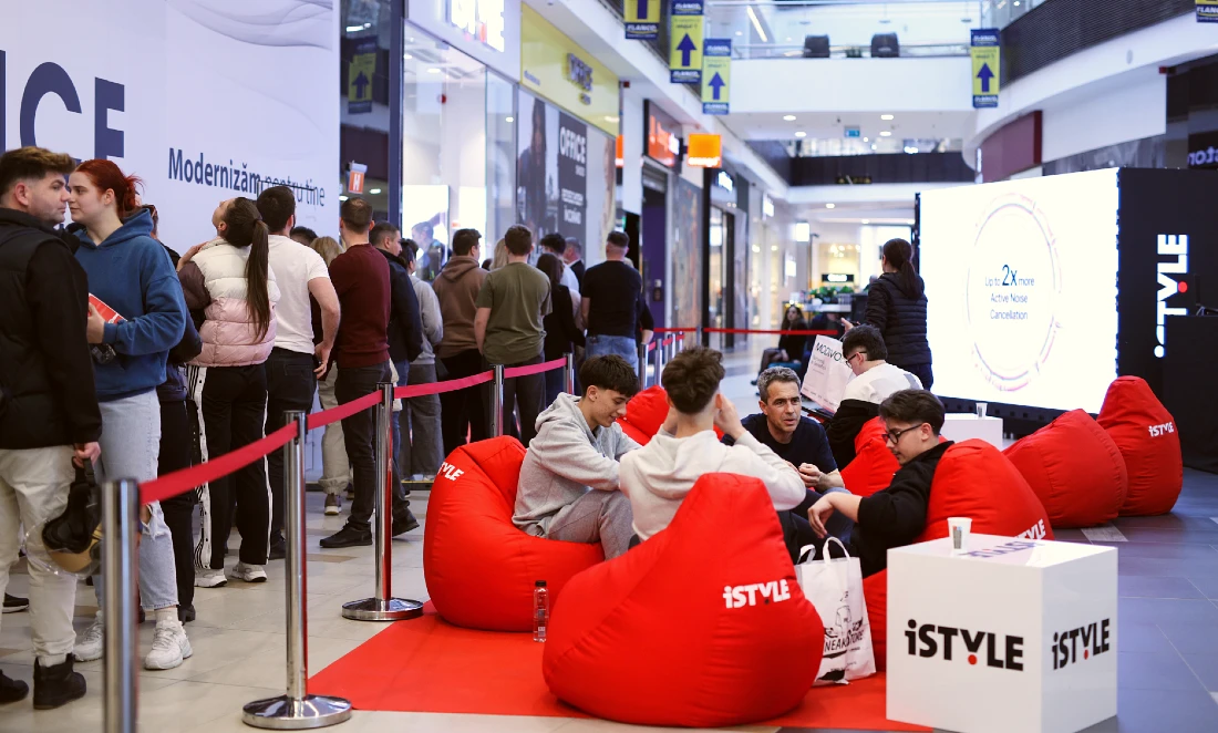people are seen relaxing at the opening of a hi tech store. They sit on red bean bag chairs.