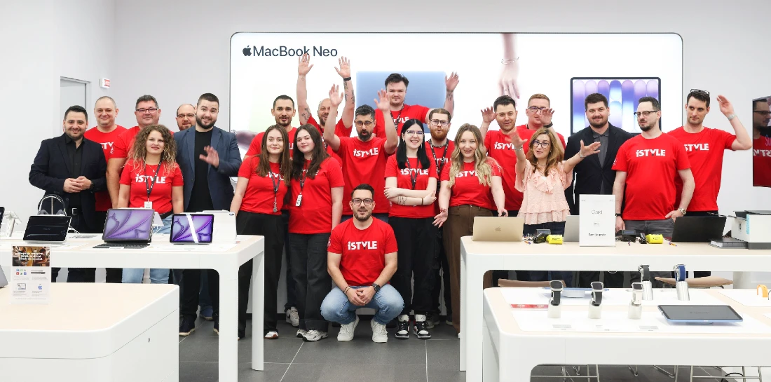 Group photograph of a staff team in a hi tech store. Most are wearing red t-shirts 